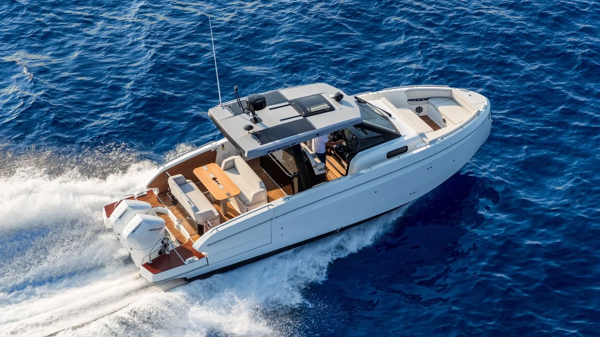 Beneteau Gran Turismo 35 — Bateau à moteur blanc vu de trois quarts, naviguant sur une mer bleue.
