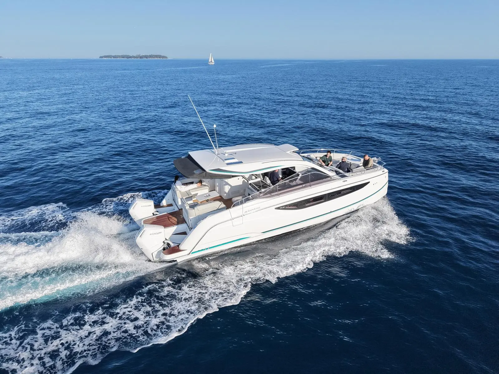 Jeanneau TH 38 — Bateau à moteur naviguant au large, vu en trois quarts arrière.