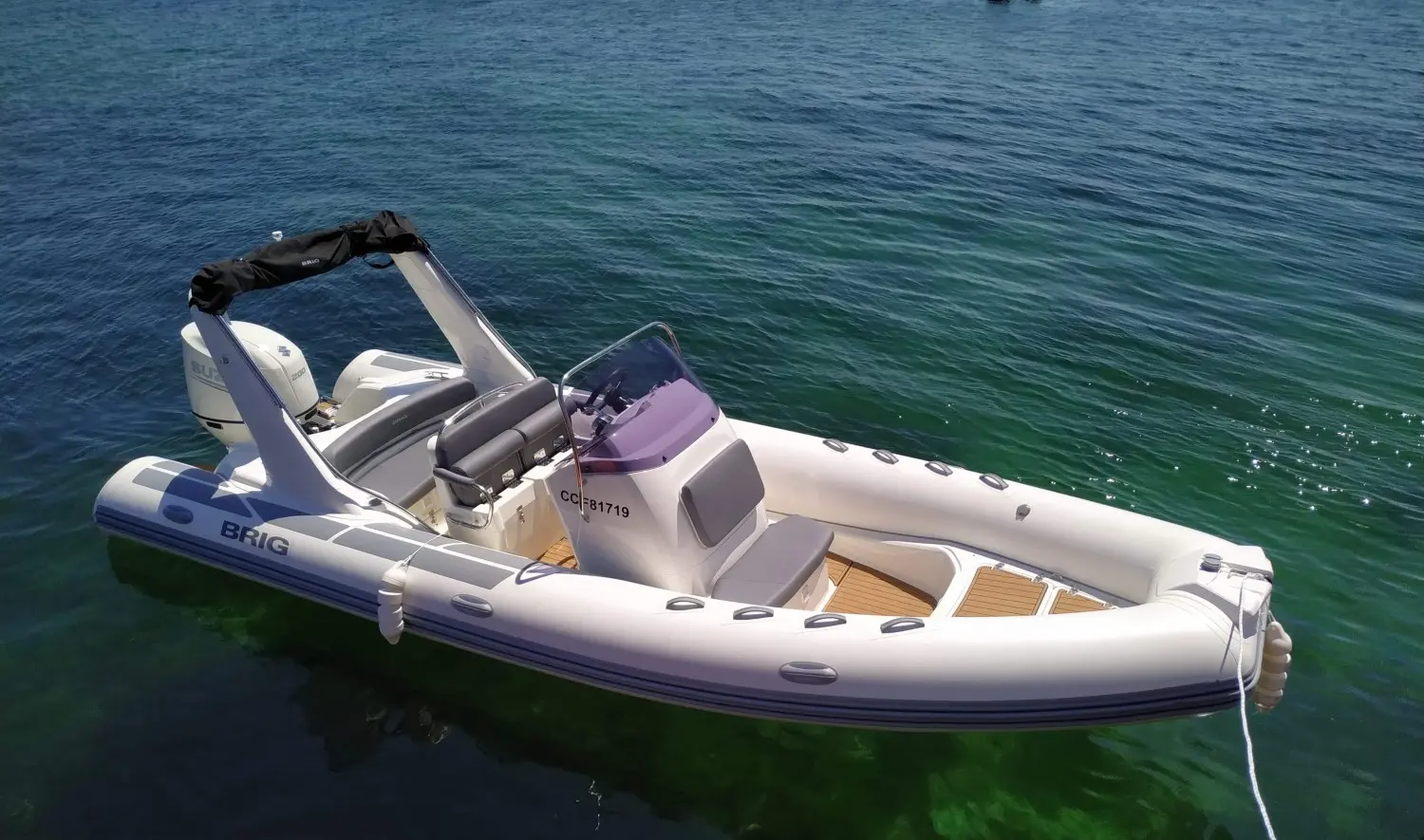 Brig Eagle 650 — Bateau pneumatique blanc vu de trois quarts sur l’eau, avec console et moteur hors-bord.