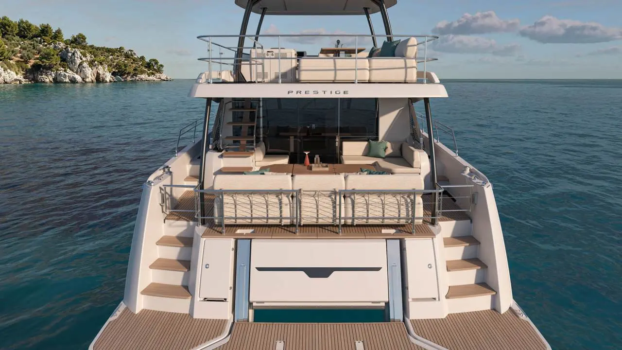 Prestige Yachts M6 — Vue arrière d’un yacht blanc avec plusieurs espaces extérieurs aménagés.