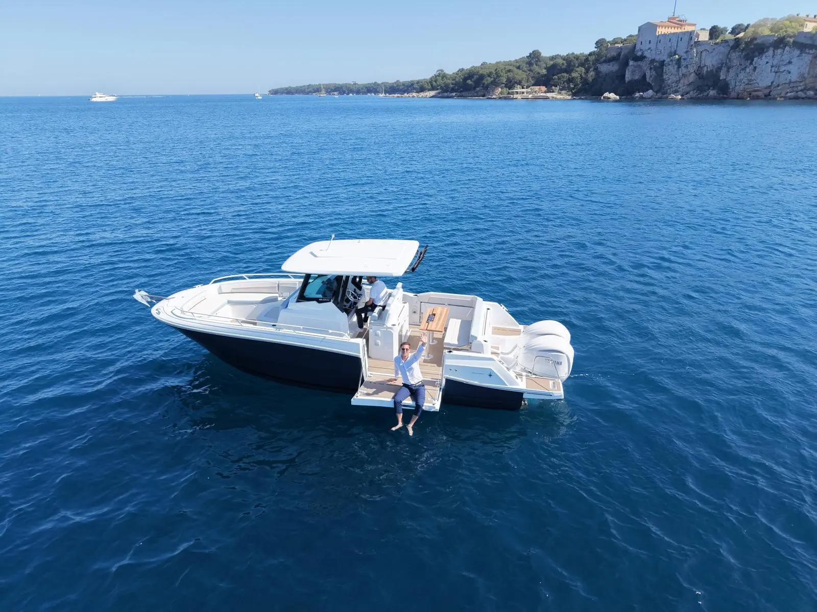 Jeanneau CAP CAMARAT 9.0 SERIE 2 — Bateau à moteur vu du dessus, avec une personne assise sur la plateforme arrière.