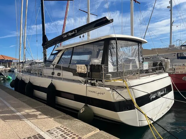 Beneteau Oceanis Yacht 62 — Bateau à moteur amarré au port, vu de trois quarts arrière.