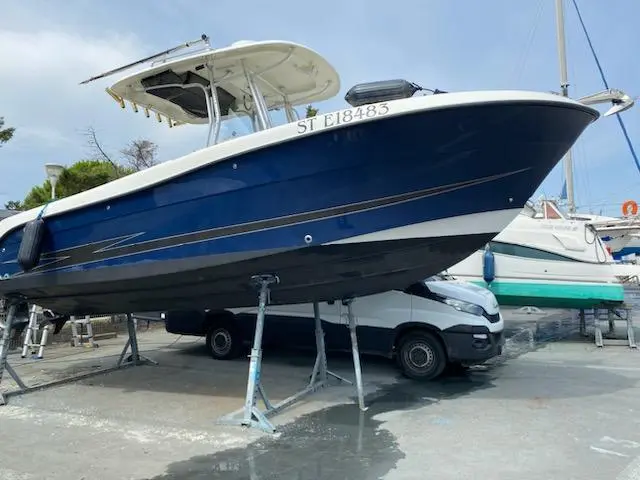 Hydrasport 2500 CC — Bateau bleu et blanc à moteur présenté sur bers dans un chantier nautique.