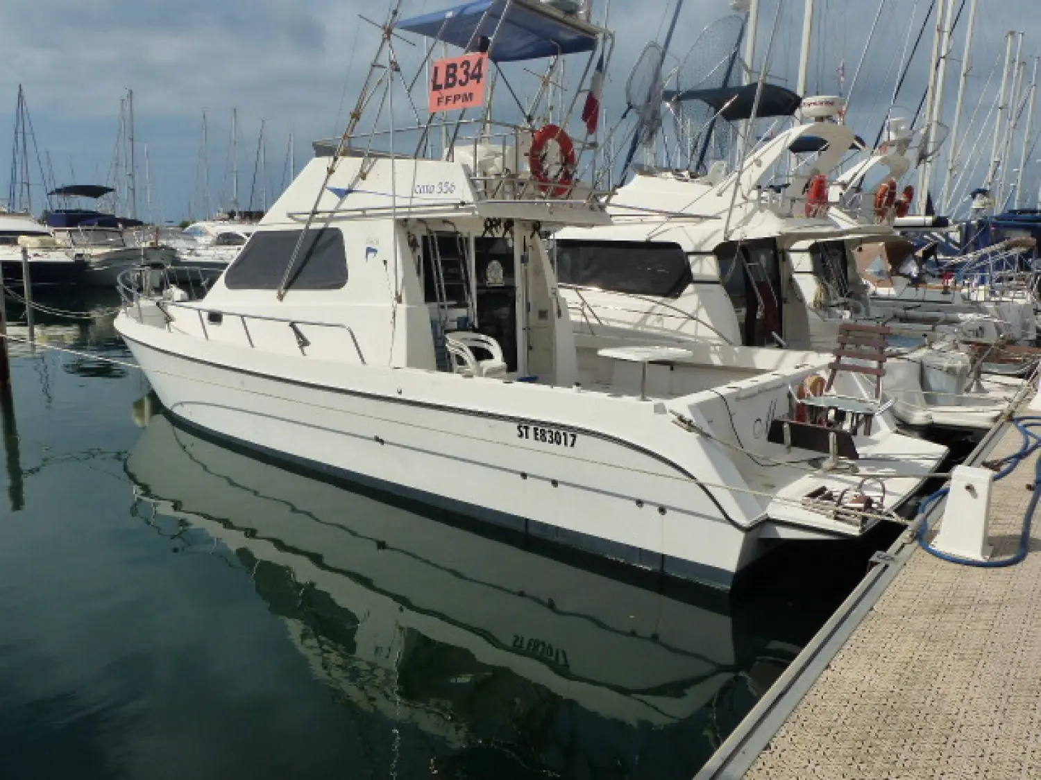 Astilleros Cata Cata 356 — Bateau à moteur blanc amarré dans une marina, vu de trois quarts arrière.