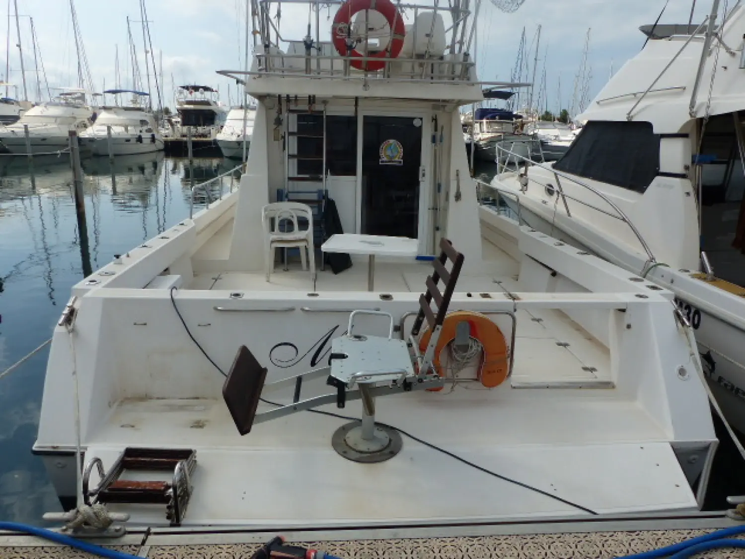 Astilleros Cata Cata 356 — Vue arrière du pont d’un bateau amarré dans une marina, avec mobilier et équipements visibles.