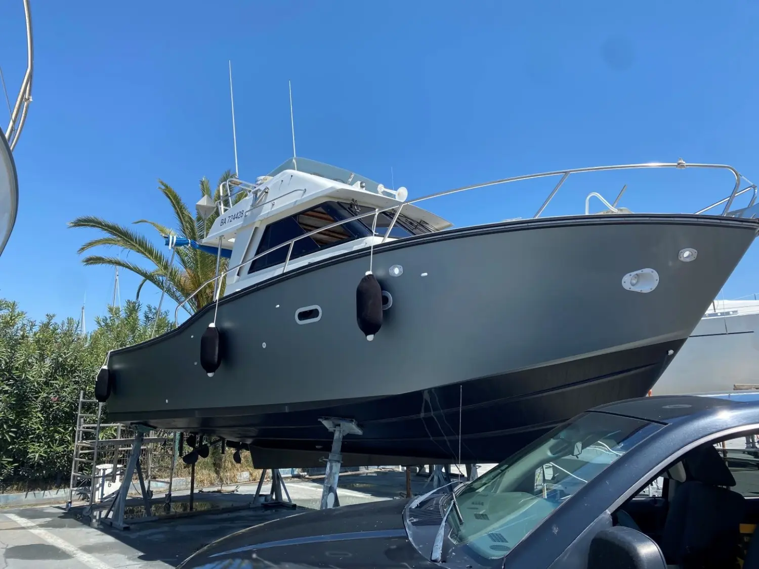Jeanneau Merry Fisher 930 — Bateau à moteur gris présenté à terre sur bers, vu en contre-plongée.