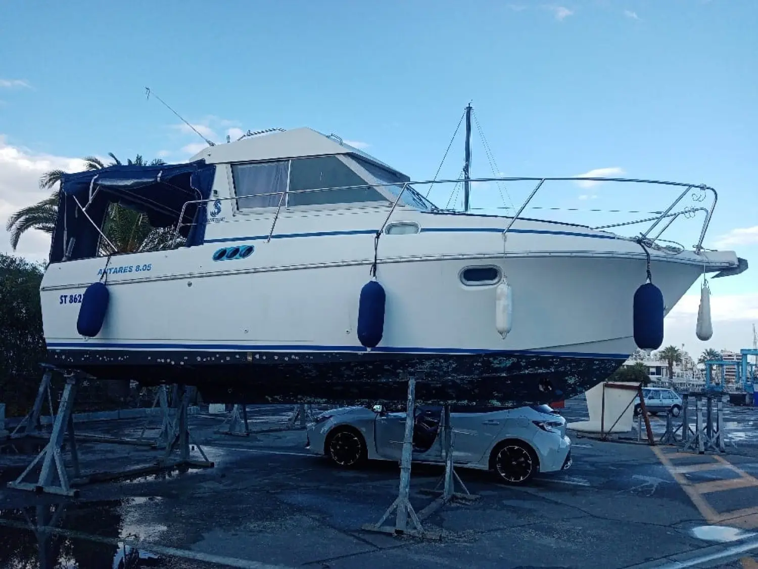 Beneteau Antares 805 — Bateau à moteur blanc photographié de profil, posé sur bers dans un chantier nautique.