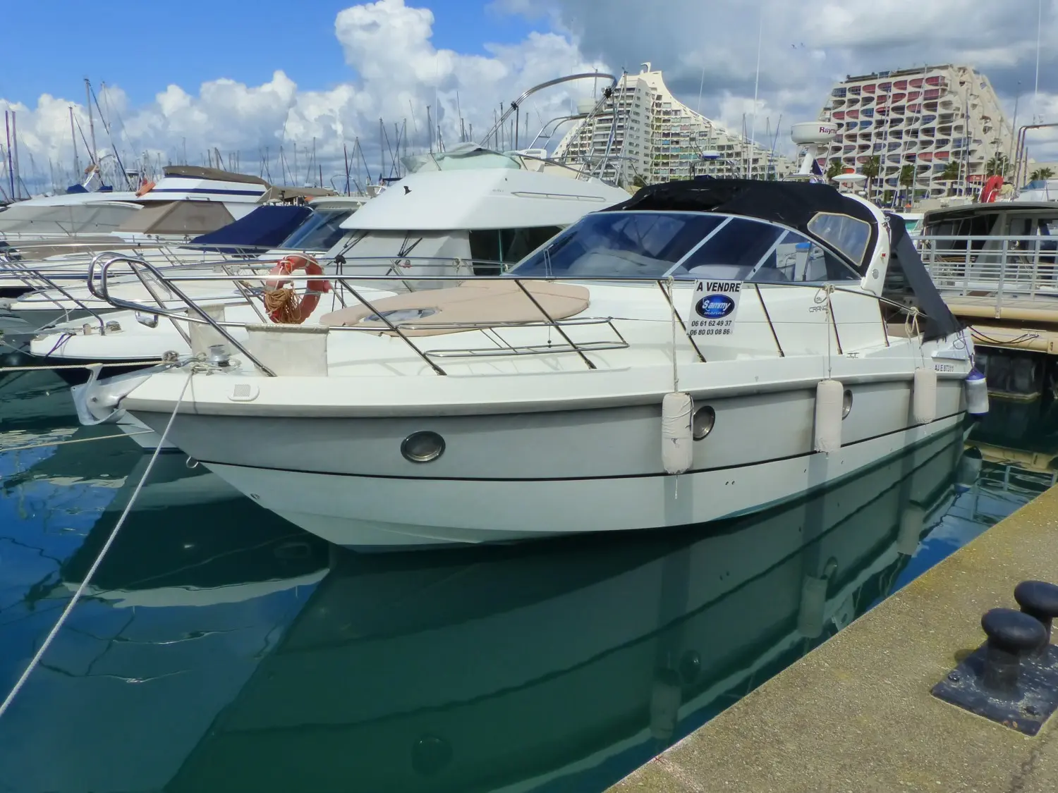Cranchi Zaffiro 32 — Bateau à moteur blanc amarré dans un port, vu de trois quarts.