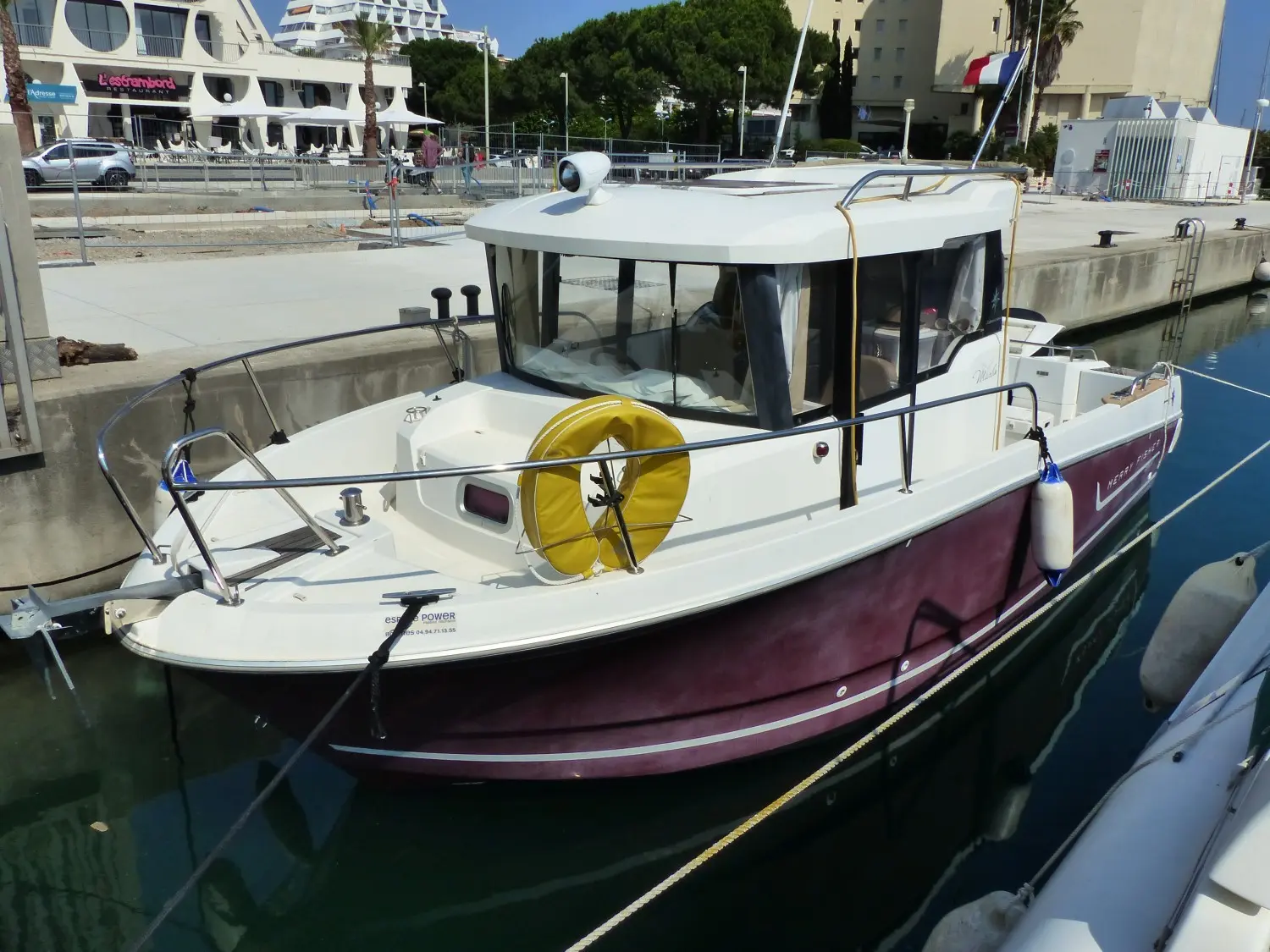 Jeanneau Merry Fisher 755 — Bateau à cabine amarré dans une marina, photographié de trois quarts bâbord.