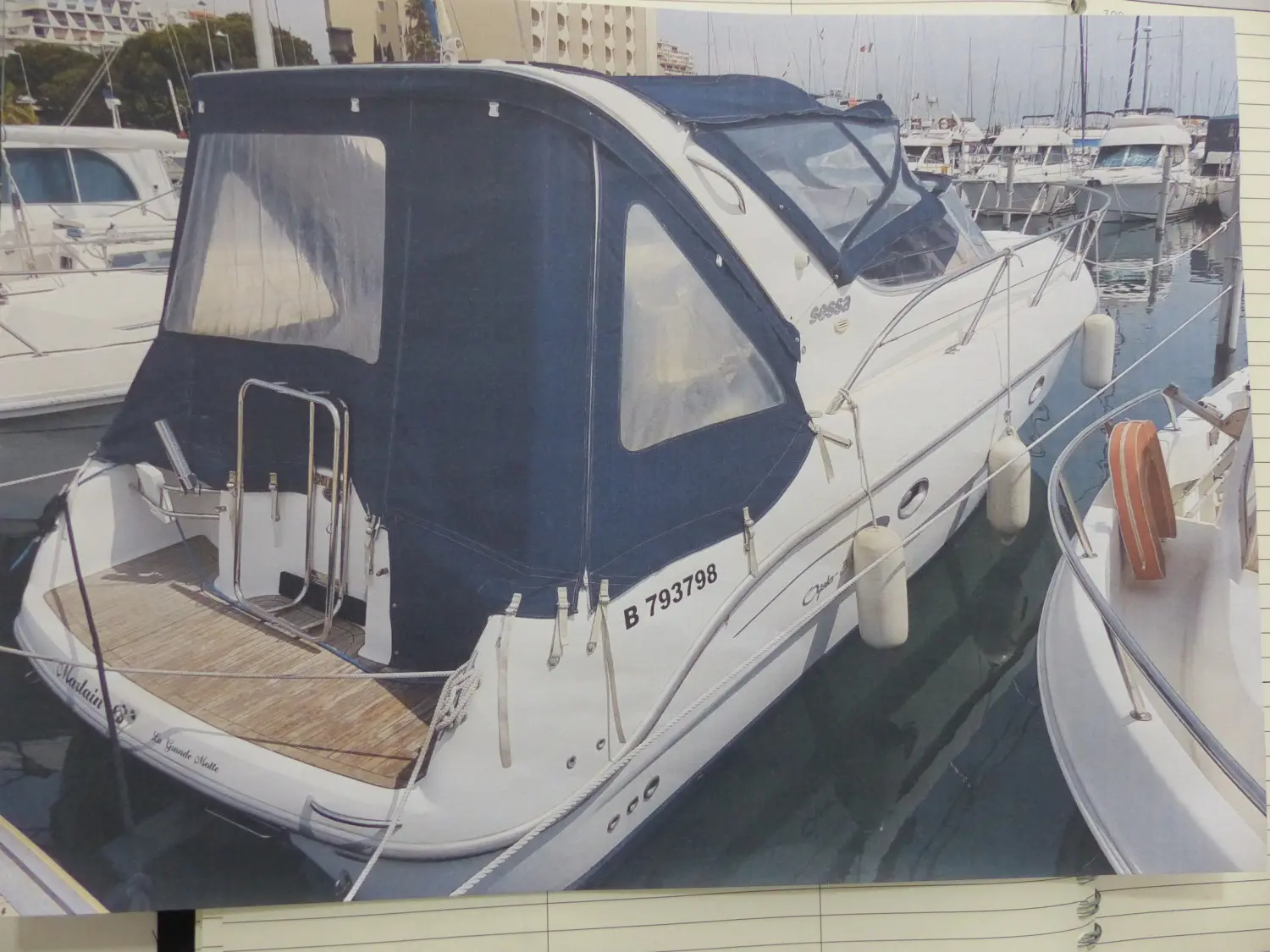 Sessa Marine Oyster 30 — Vedette blanche à cabine amarrée dans une marina, vue de trois quarts arrière.