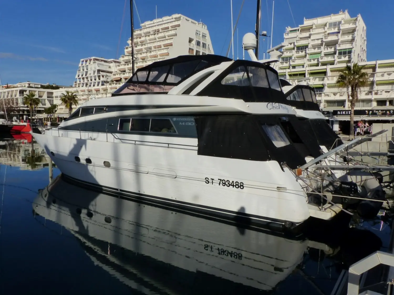 Mondomarine M 60 — Bateau à moteur blanc amarré dans un port, photographié de trois quarts arrière.