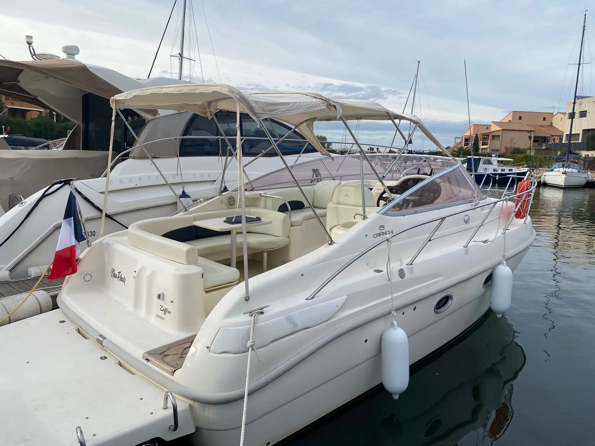 Cranchi Zaffiro 28 — Bateau à moteur blanc vu de trois quarts arrière dans un port.