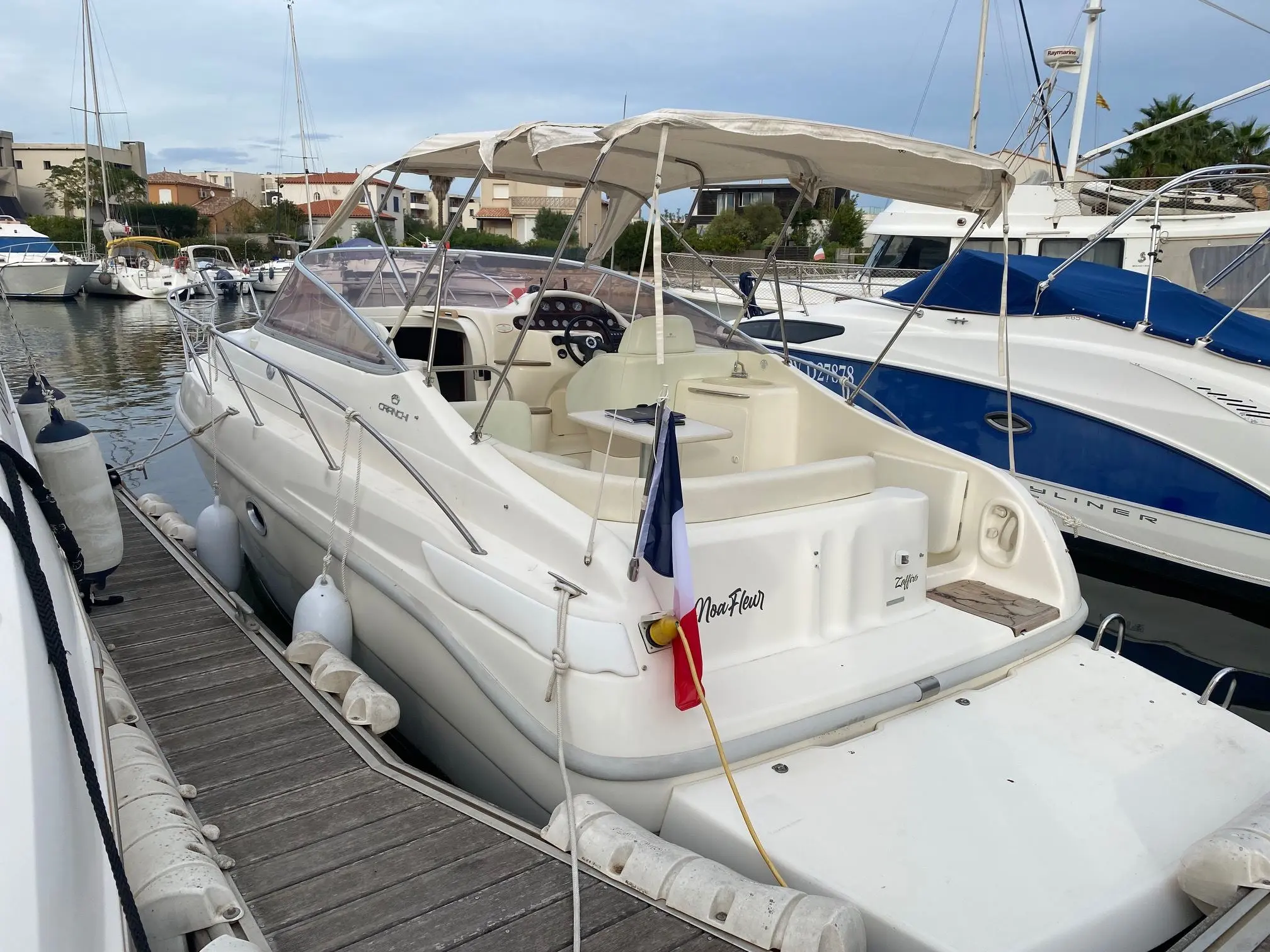 Cranchi Zaffiro 28 — Bateau à moteur blanc amarré au port, photographié en vue arrière trois quarts.