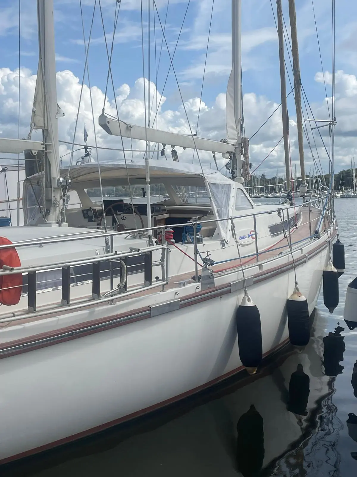 Amel Super Maramu — Voilier amarré vu de trois quarts, avec cockpit, gréement et défenses visibles.