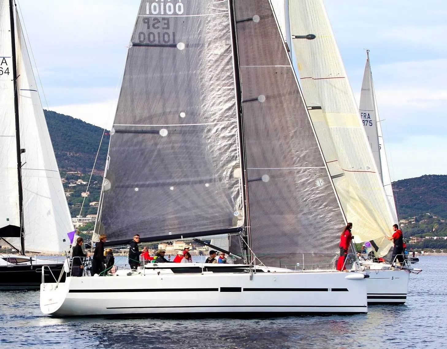 Dufour 36 — Voilier blanc vu de profil, sous voiles, avec plusieurs personnes à bord.