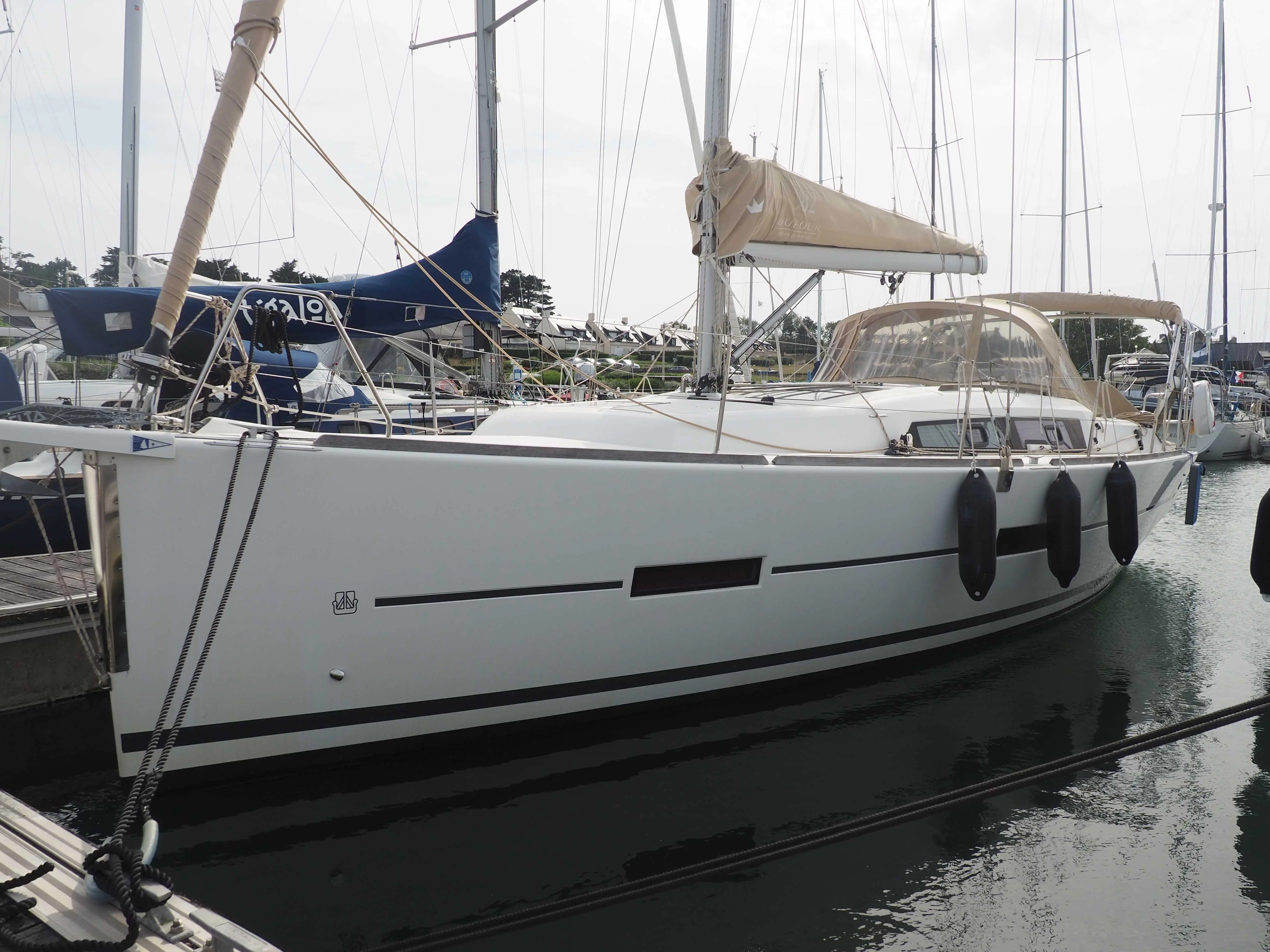 Dufour 382 Grand Large — Voilier blanc amarré, vu de profil dans un port de plaisance.