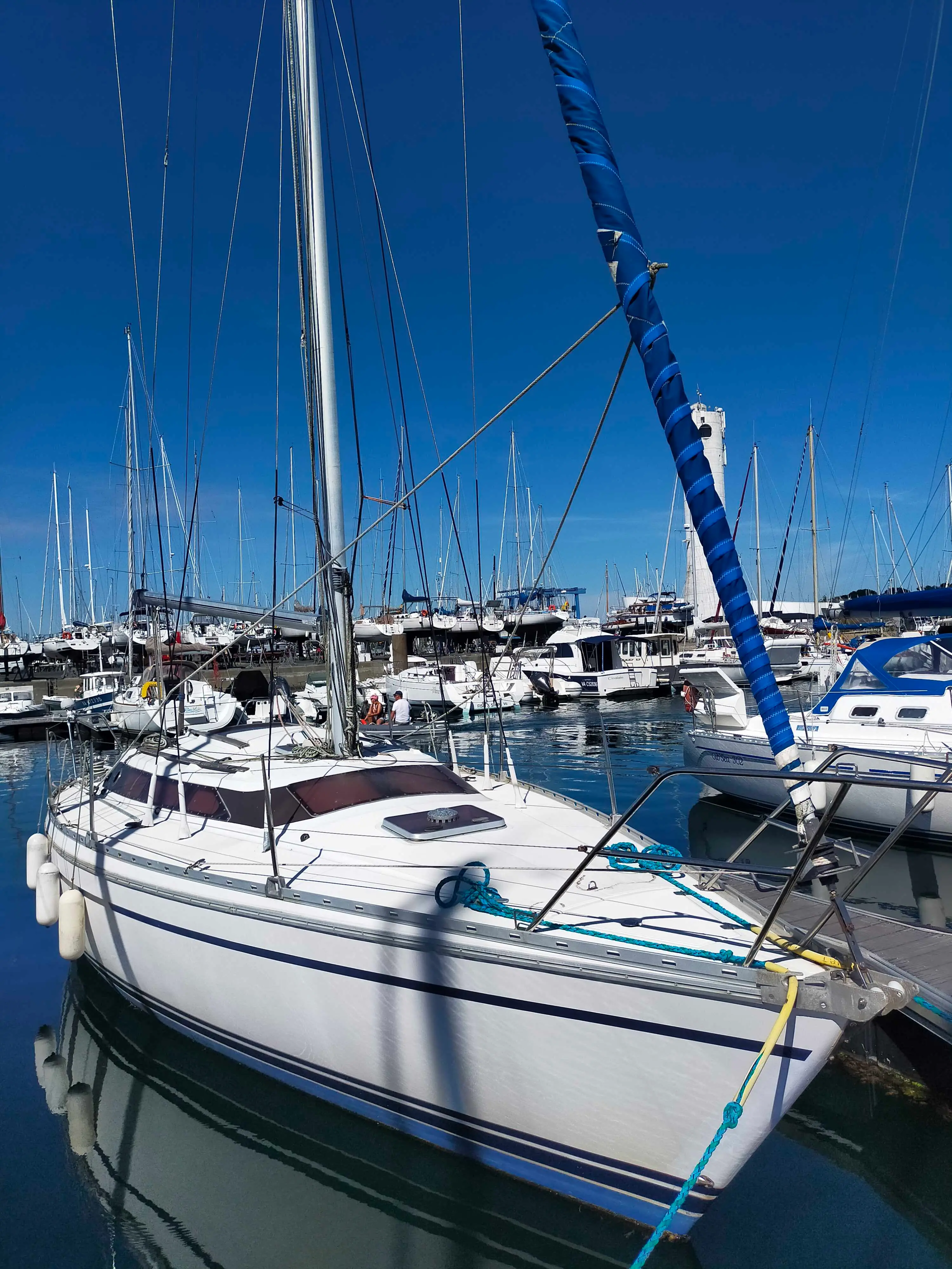 Jeanneau Attalia — Voilier blanc amarré dans un port, vu de trois quarts avant.