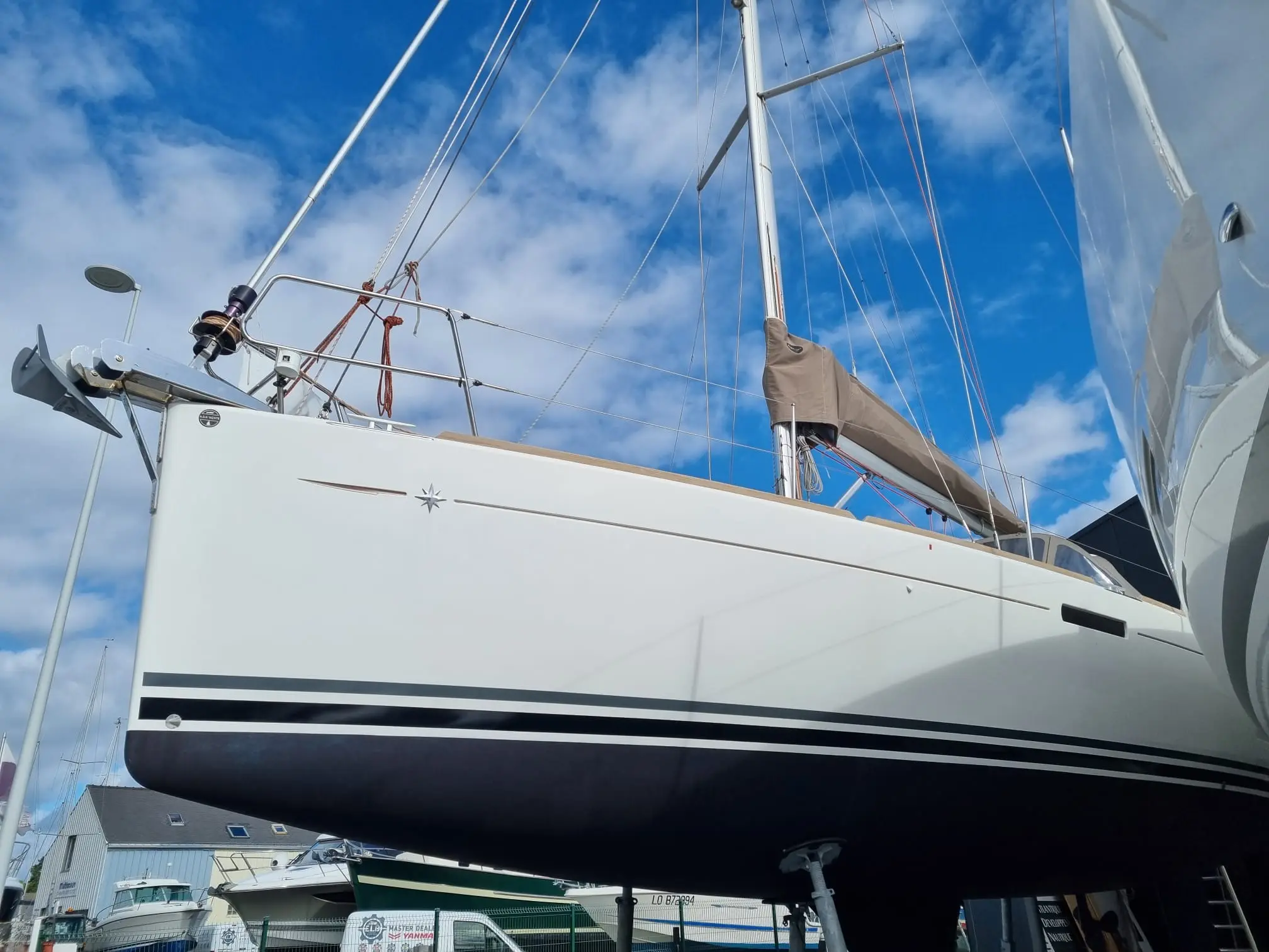 Jeanneau Sun Odyssey 379 — Voilier blanc photographié à terre, vu de profil depuis un angle bas.