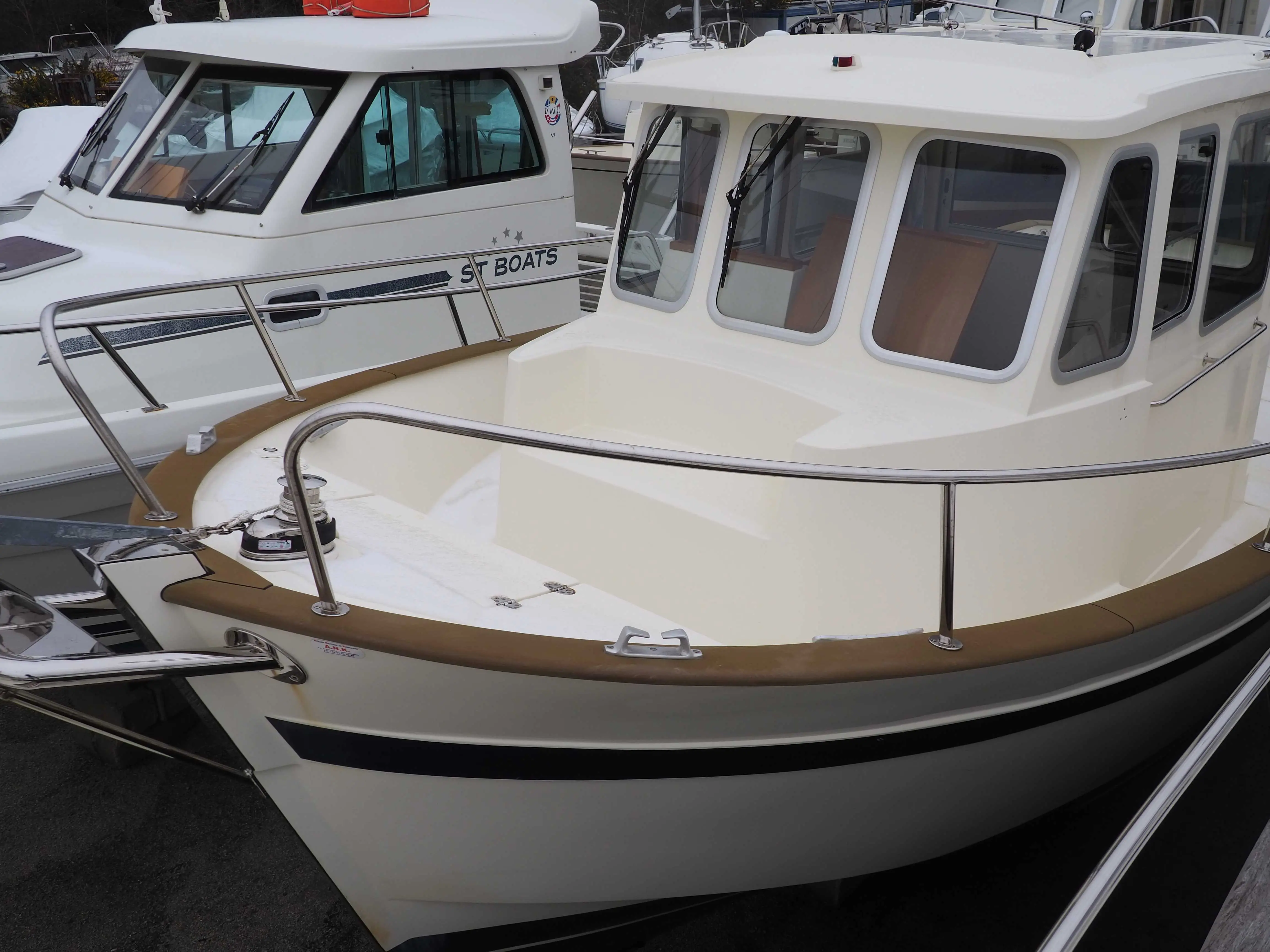 Rhea 730 Fishing — Vue rapprochée de l’avant et de la timonerie d’un bateau blanc amarré.