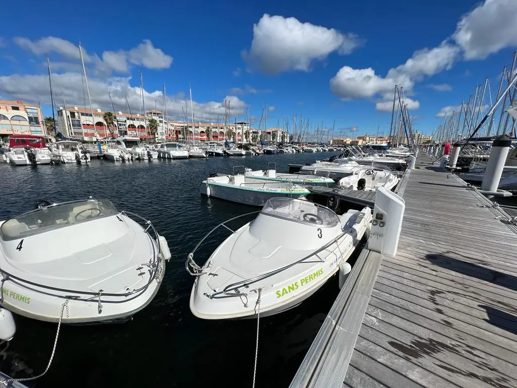 Conero 480 — Deux bateaux blancs amarrés dans une marina, avec d'autres embarcations en arrière-plan.
