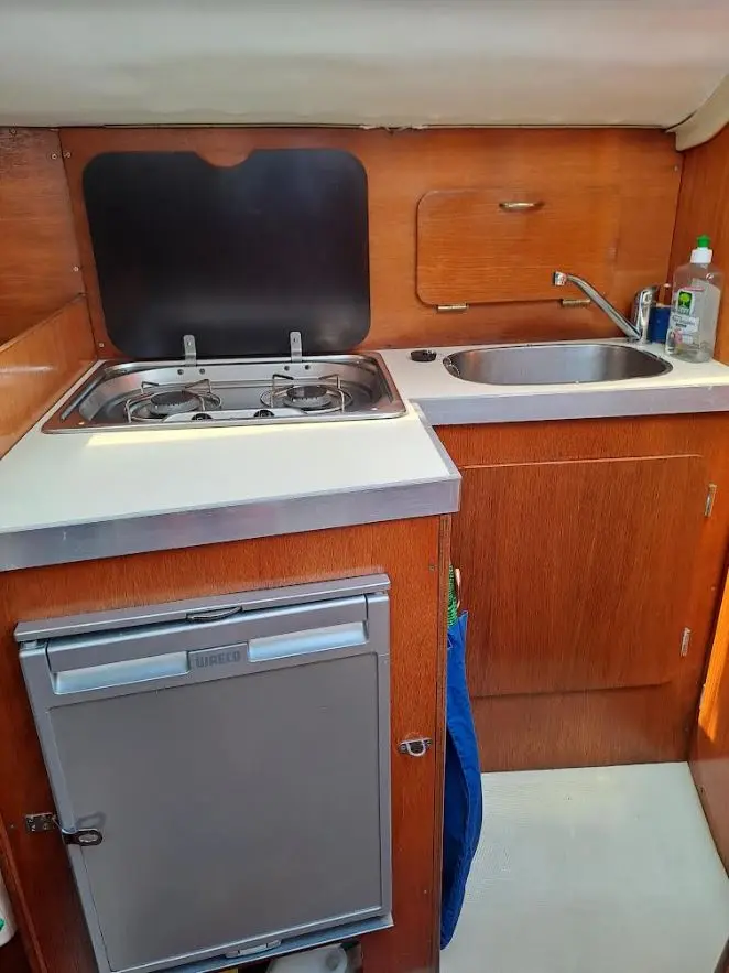 Yachting France Jouet 760 — Cuisine intérieure avec réchaud double, évier et réfrigérateur à bord.