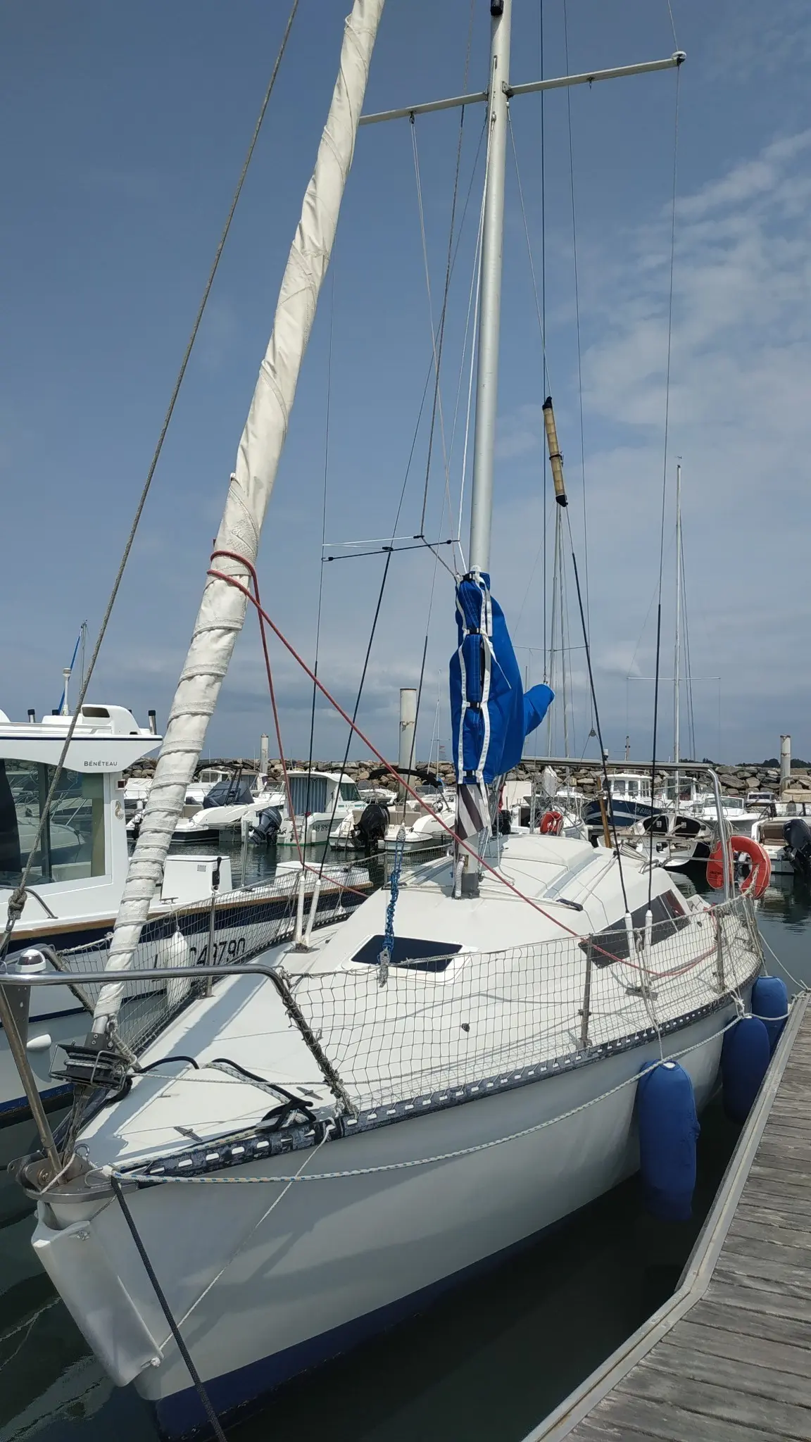 Yachting France Jouet 760 — Voilier blanc amarré dans un port, vu de trois quarts avant.