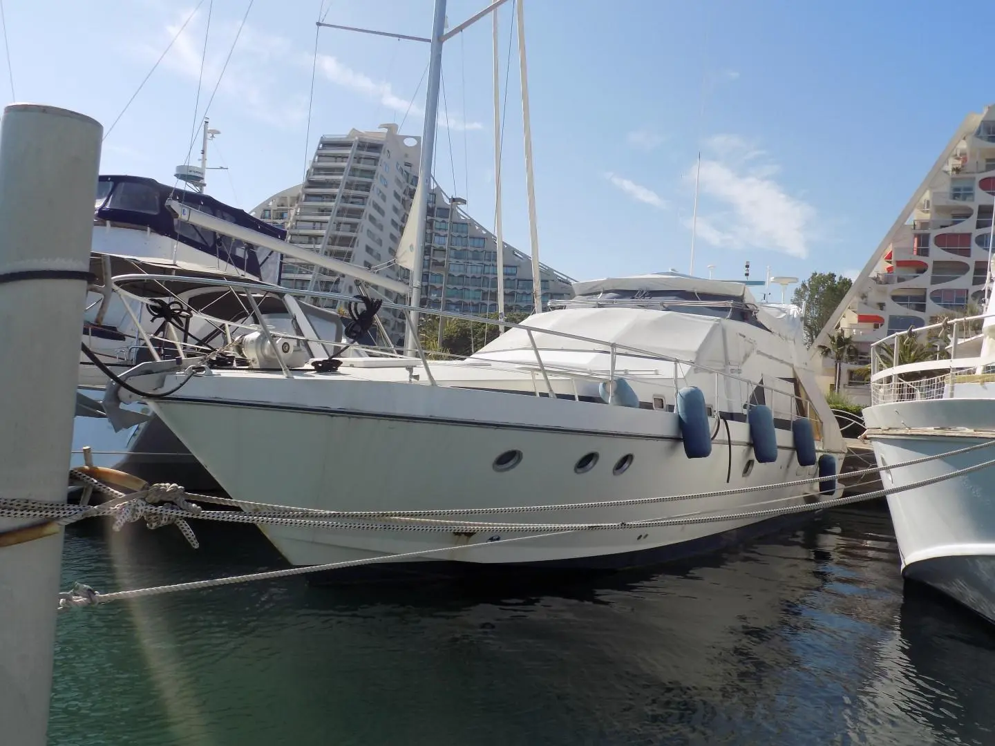 Guy Couach 1501 CL — Bateau à moteur blanc amarré dans une marina, vu de trois quarts.