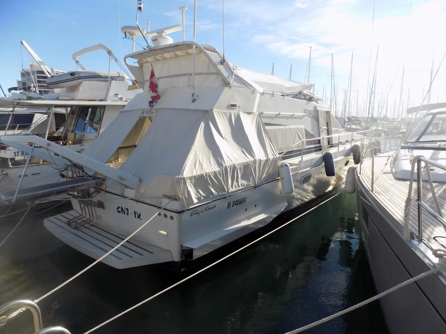Guy Couach 1501 CL — Vue arrière tribord d’un yacht à moteur amarré, partiellement couvert au port.