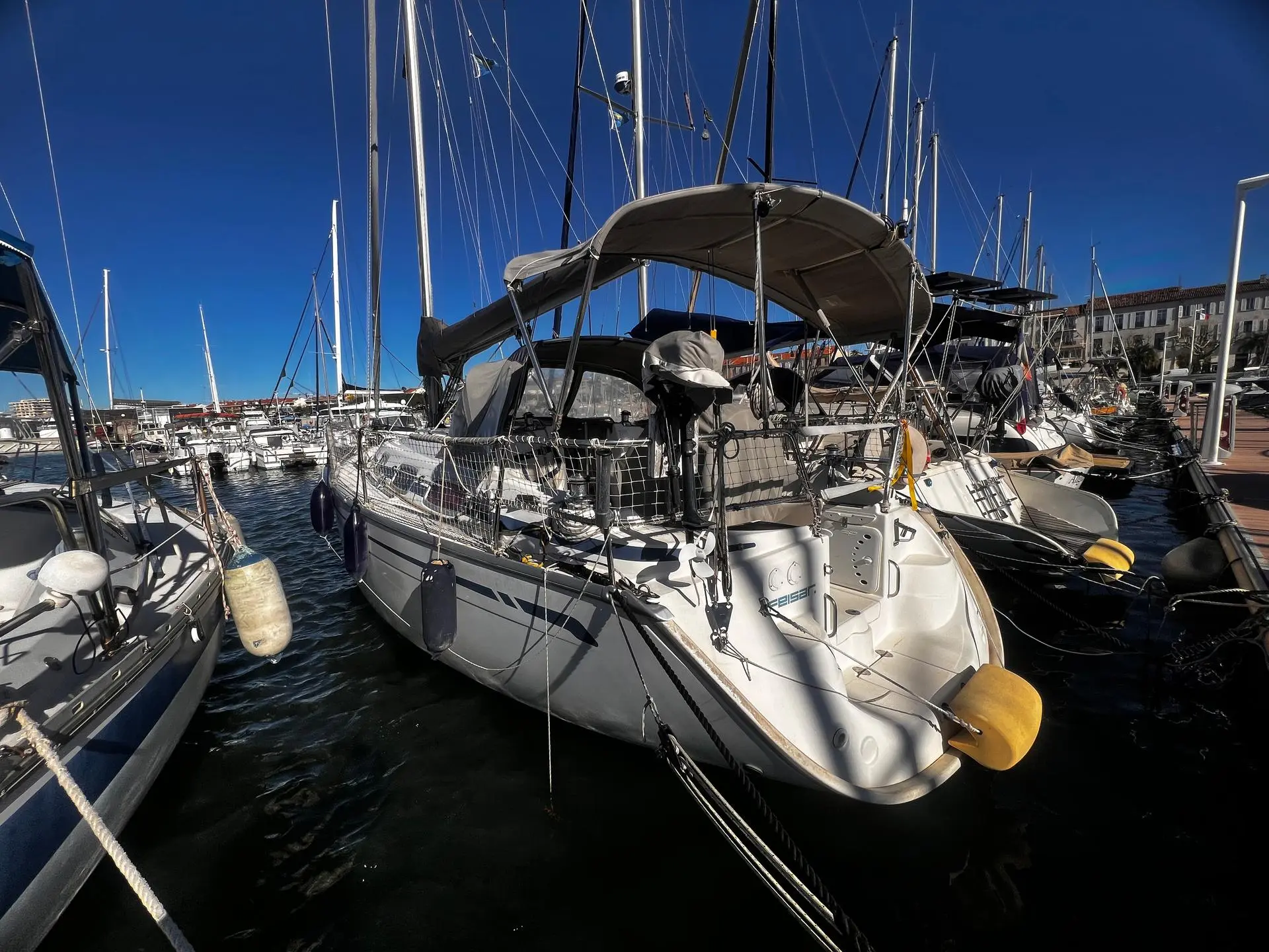 Bavaria 30 — Voilier blanc amarré dans un port, photographié de trois quarts arrière.