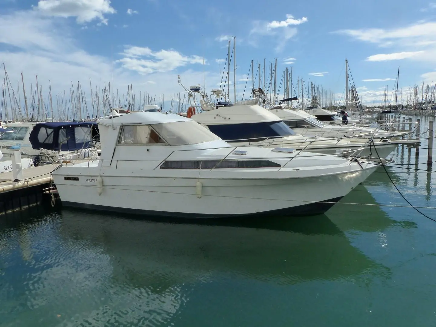 Arcoa 970 — Bateau à moteur blanc amarré dans un port de plaisance, vu de trois quarts.
