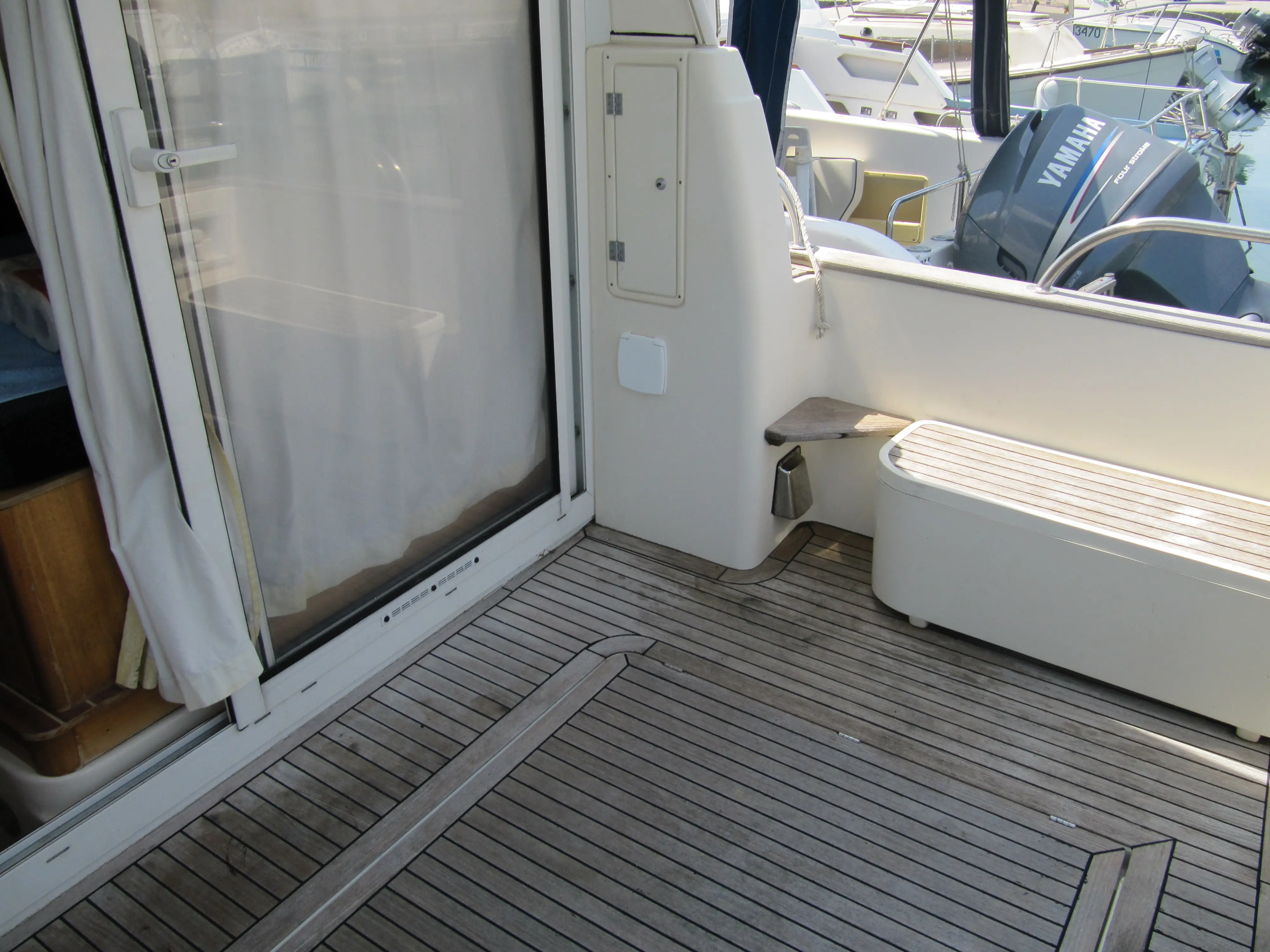 ACM Heritage 26 — Vue du cockpit arrière avec pont en teck, banquette et accès à la cabine.