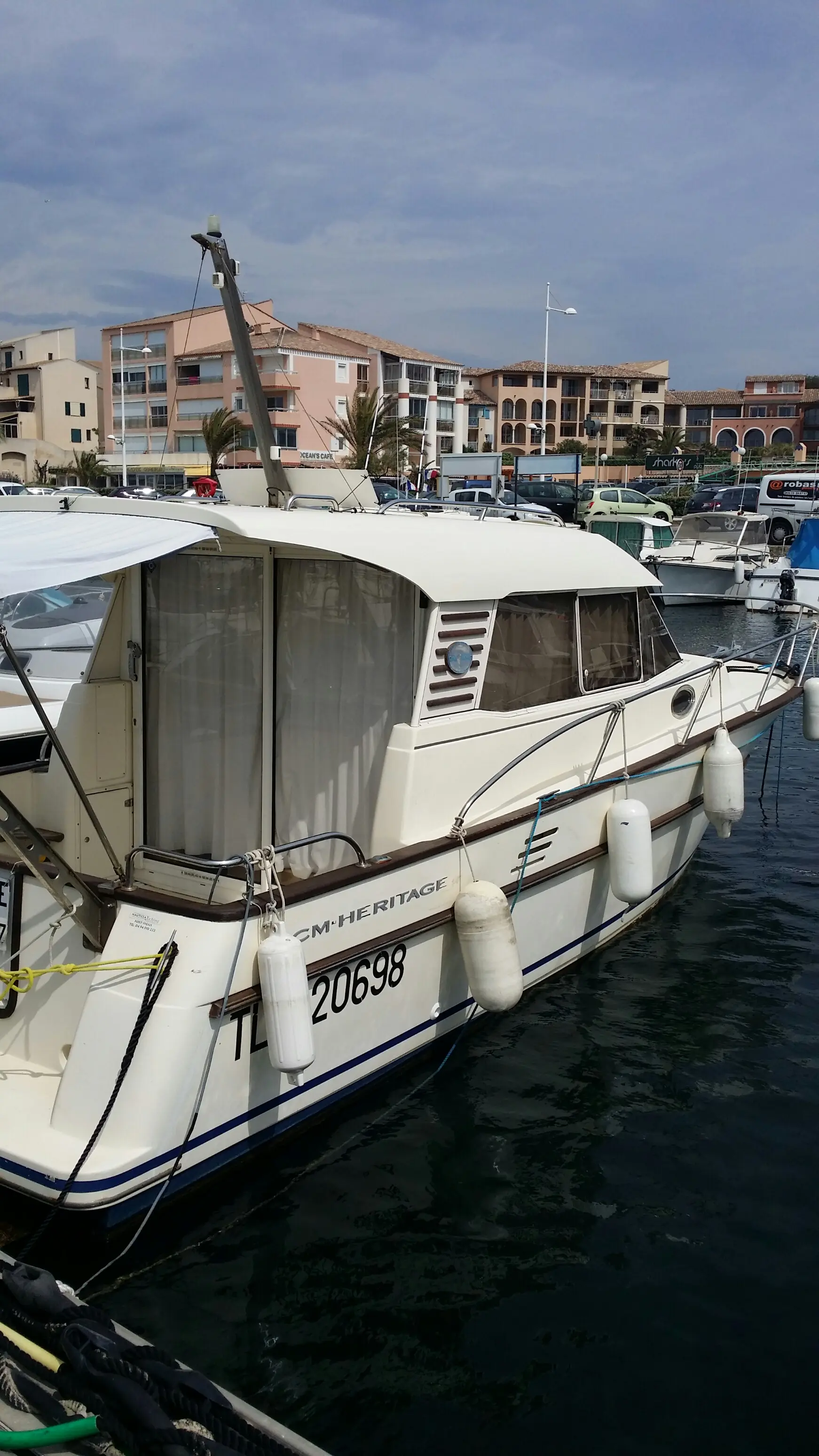 ACM Heritage — Bateau à moteur amarré dans un port, photographié de trois quarts avant.