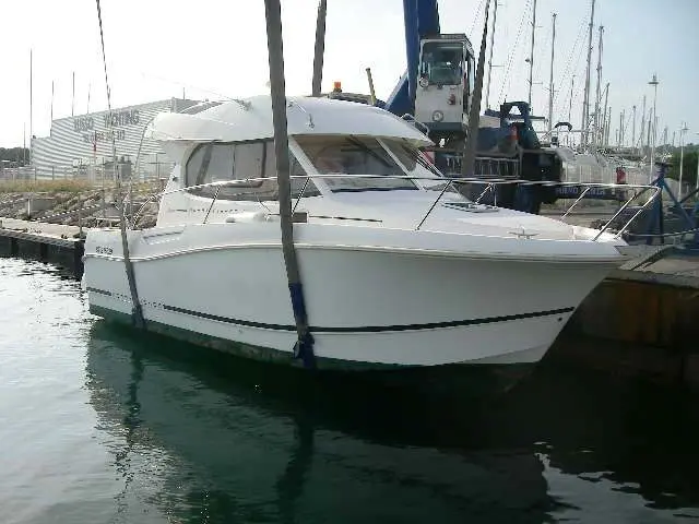 Jeanneau Merry Fisher 8 — Bateau à moteur blanc amarré dans un port, vu de trois quarts avant.