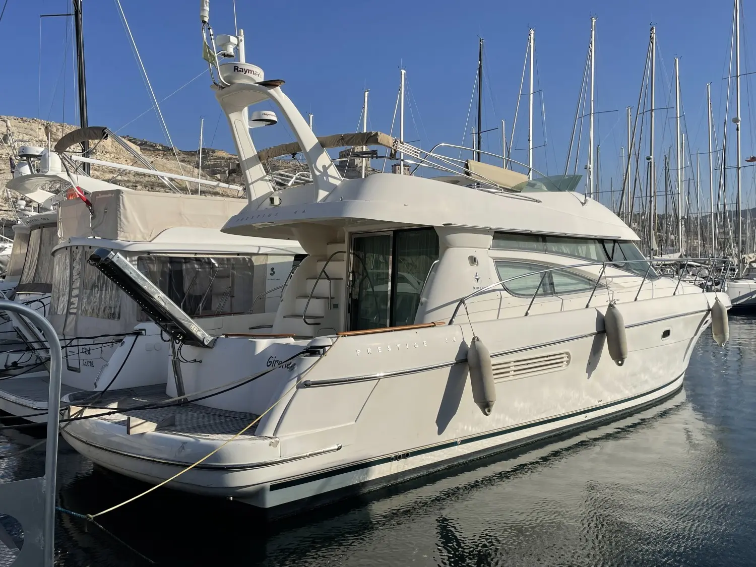 Jeanneau Prestige 46 — Bateau à moteur blanc photographié de trois quarts dans un port.