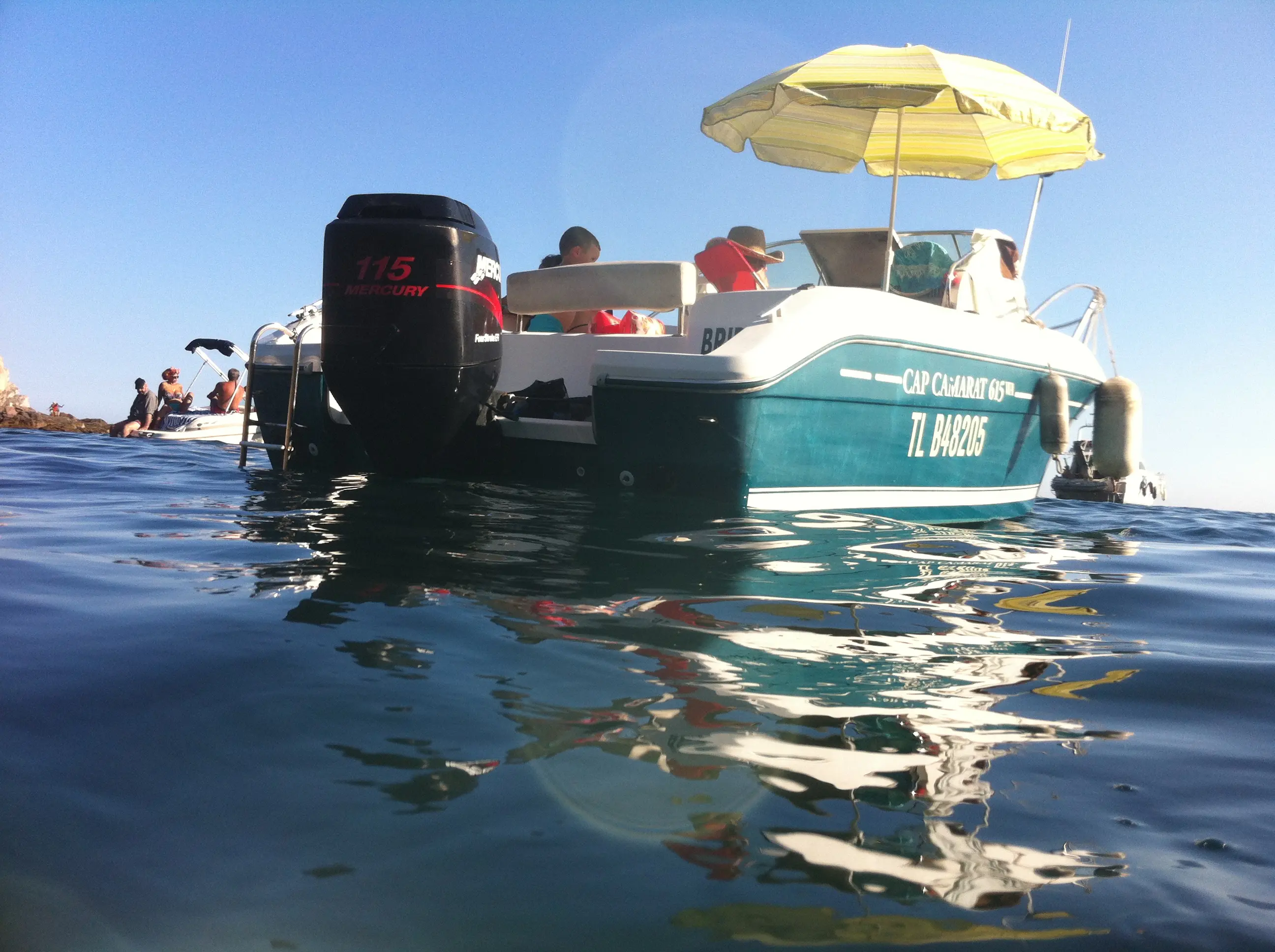 Jeanneau Cap Camarat 615 — Bateau à moteur turquoise vu depuis la surface, avec des personnes à bord.