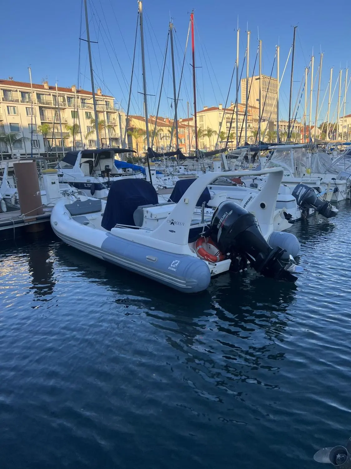 Zodiac Medline — Semi-rigide blanc amarré dans un port, équipé d’un moteur hors-bord.