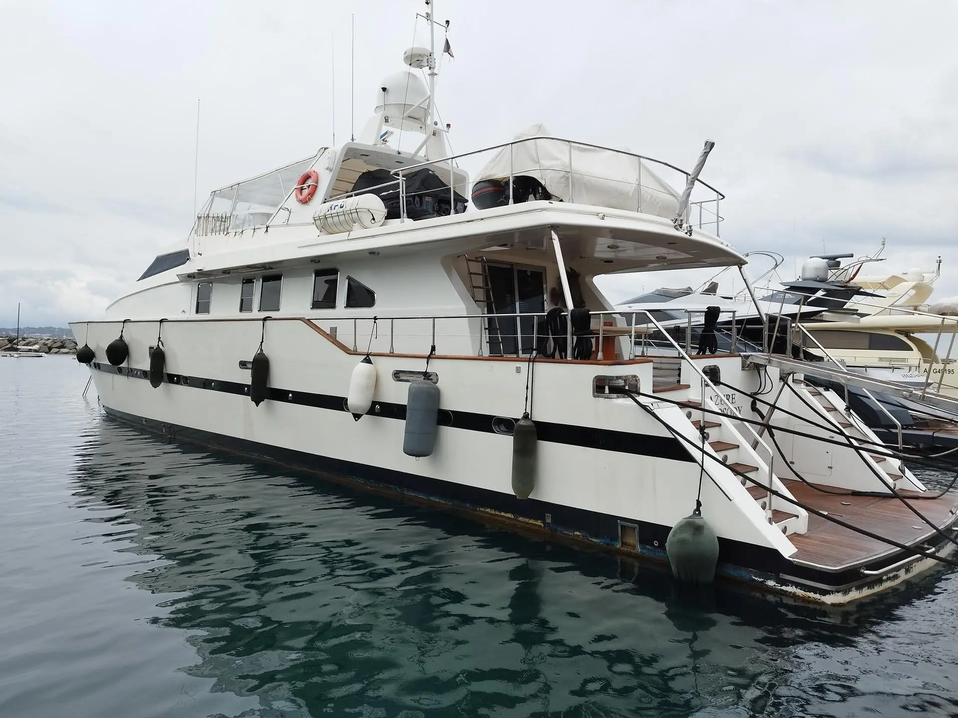 Azimut 90 — Vue trois quarts arrière d’un grand yacht blanc amarré dans une marina.