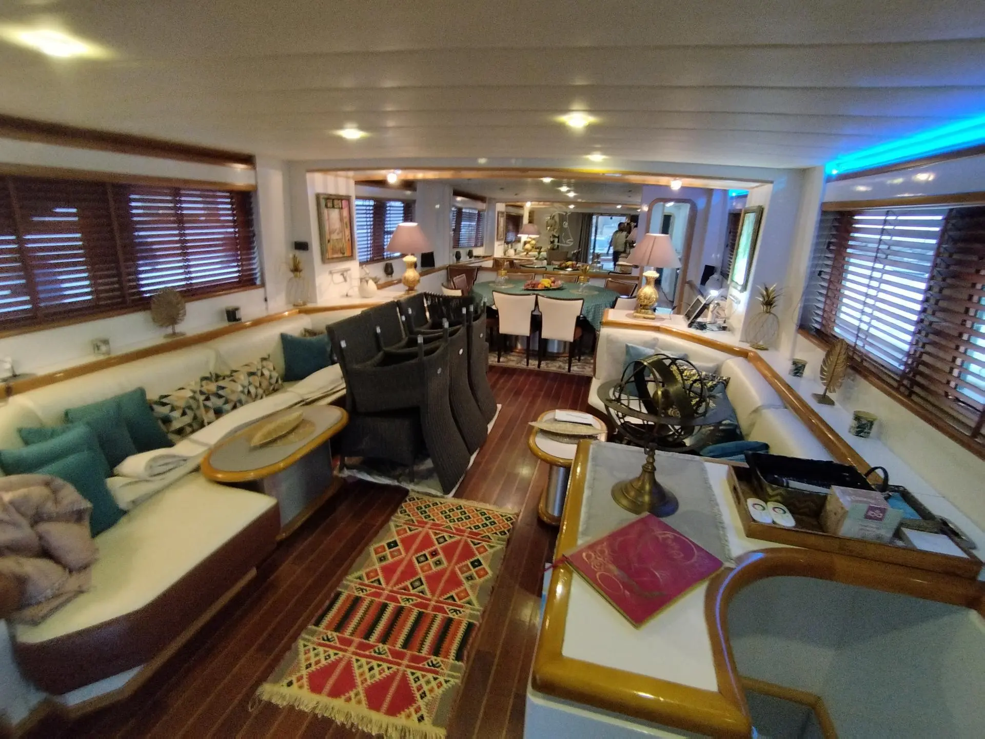 Azimut 90 — Vue intérieure d’un salon de bateau avec coin repas et poste de pilotage.