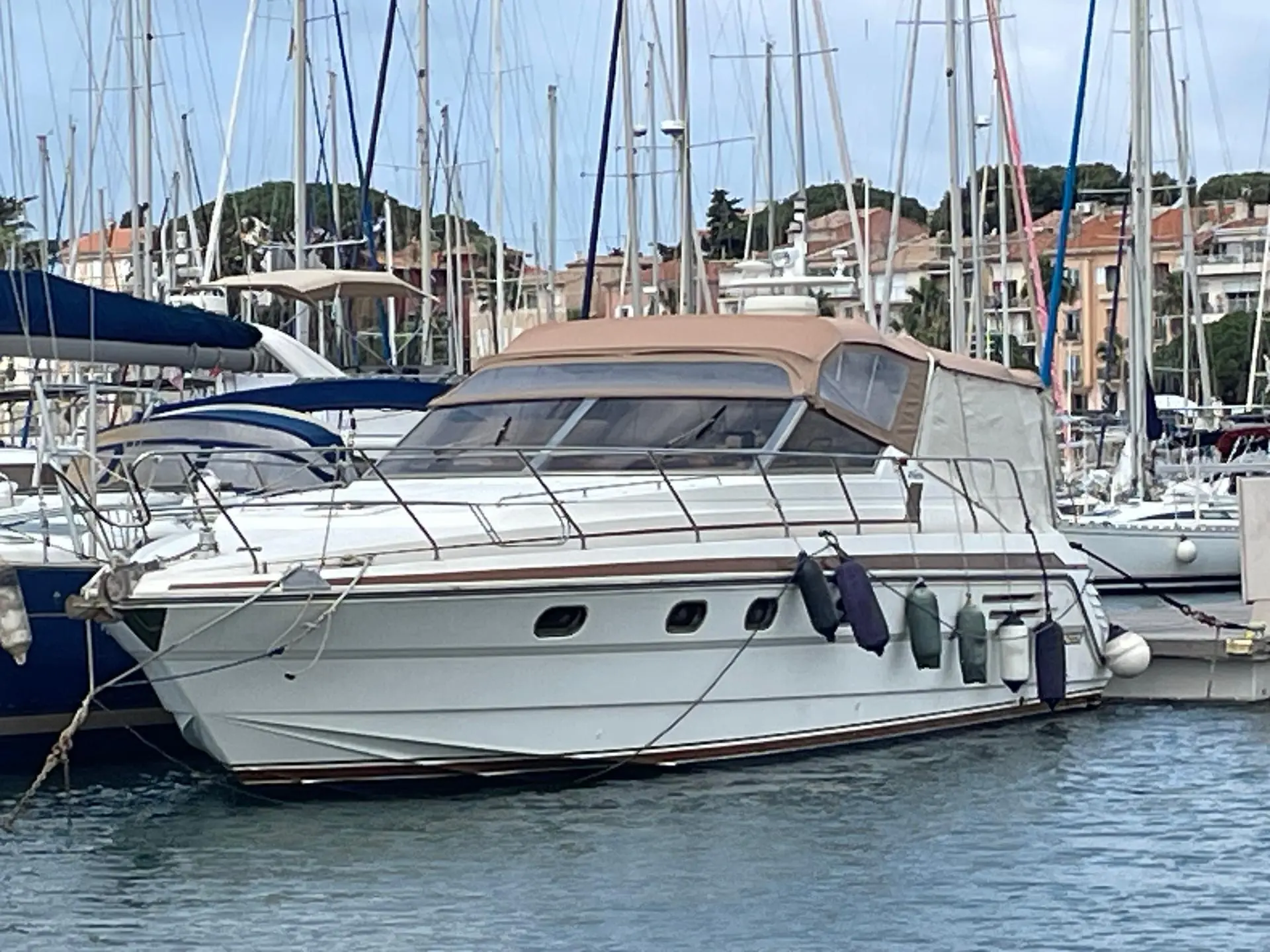 Princess 46 Riviera — Bateau à moteur blanc amarré dans une marina, vu de profil.