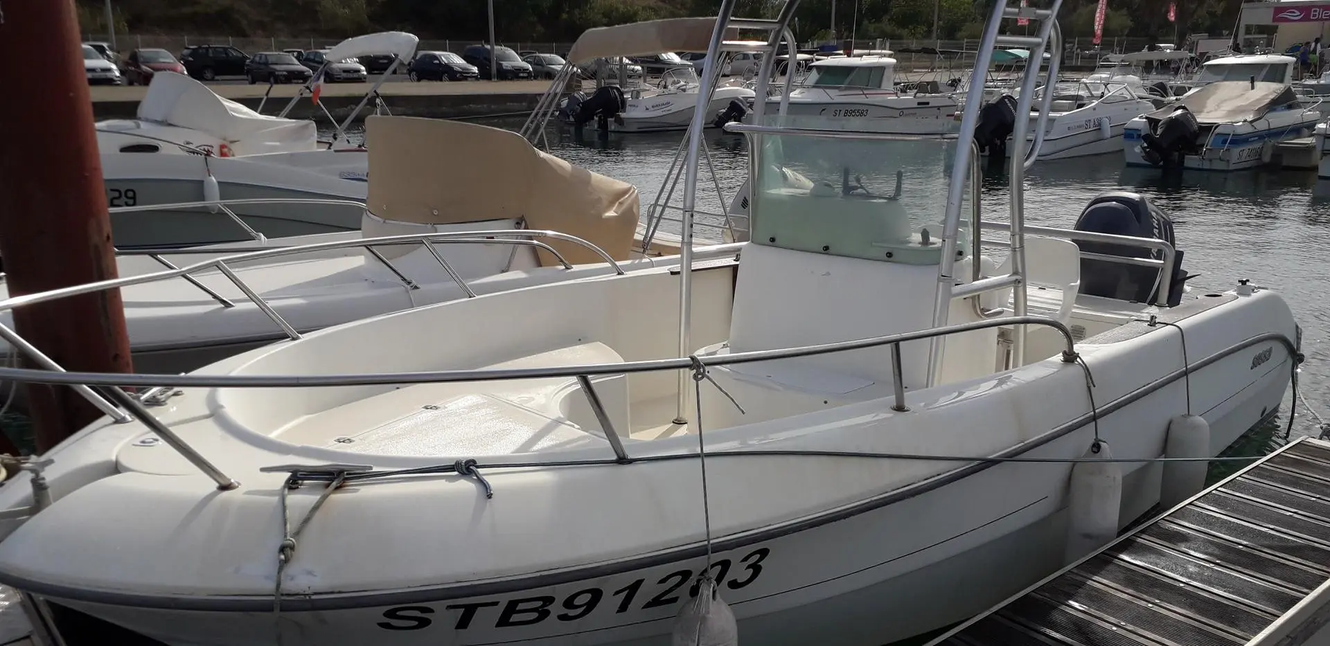 Sessa Marine Key Largo 20 — Vue en trois quarts d’un bateau à moteur blanc amarré dans un port.