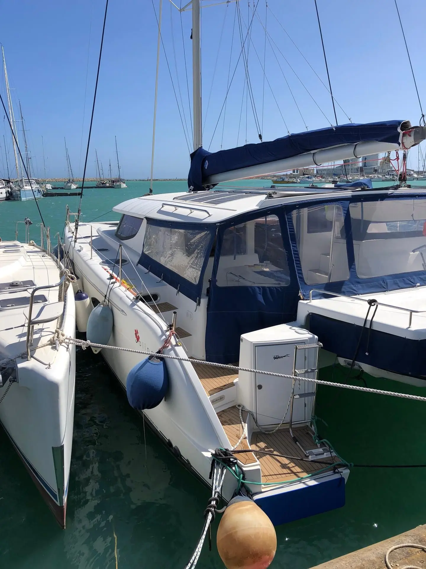 Fountaine Pajot Salina 48 — Catamaran amarré dans une marina, avec cockpit et gréement visibles.