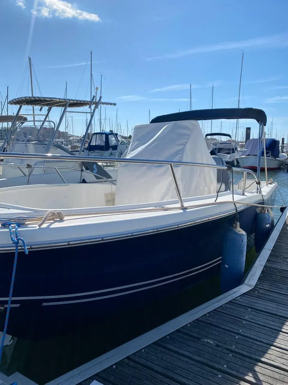 White Shark 205 — Bateau à coque sombre amarré dans un port de plaisance, vu depuis le quai.