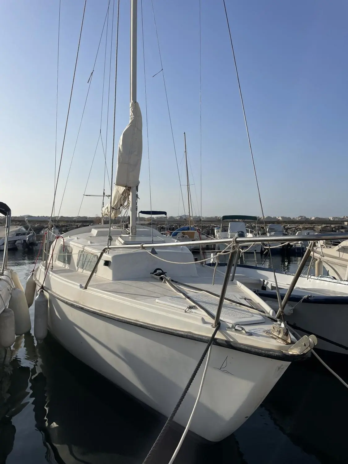 CNSO Daimio — Voilier blanc amarré dans un port, photographié de trois quarts avant.