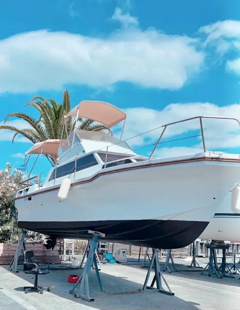 Jeanneau Imperator 900 — Bateau à moteur blanc photographié sur berceau dans une zone de maintenance.