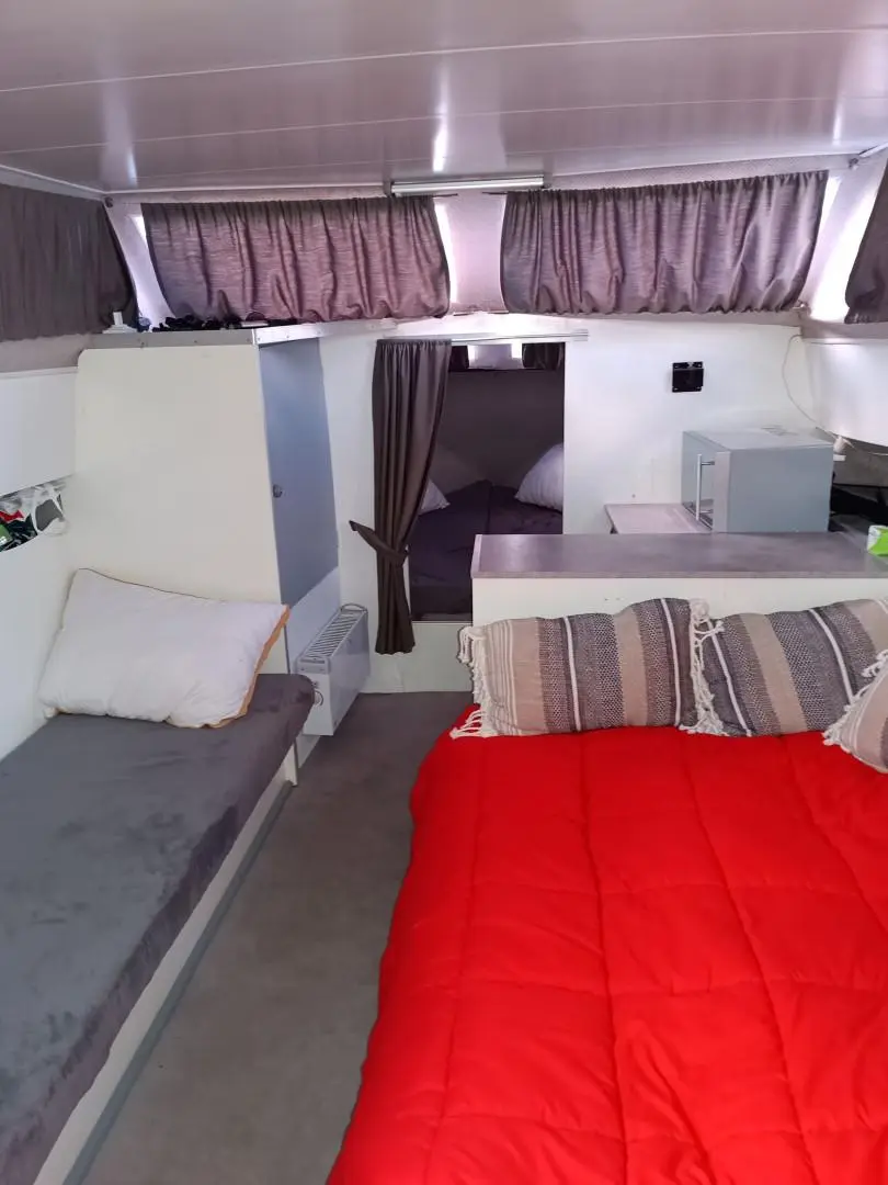 Jeanneau Imperator 900 — Vue intérieure d’une cabine avec couchettes, rideaux et rangements.