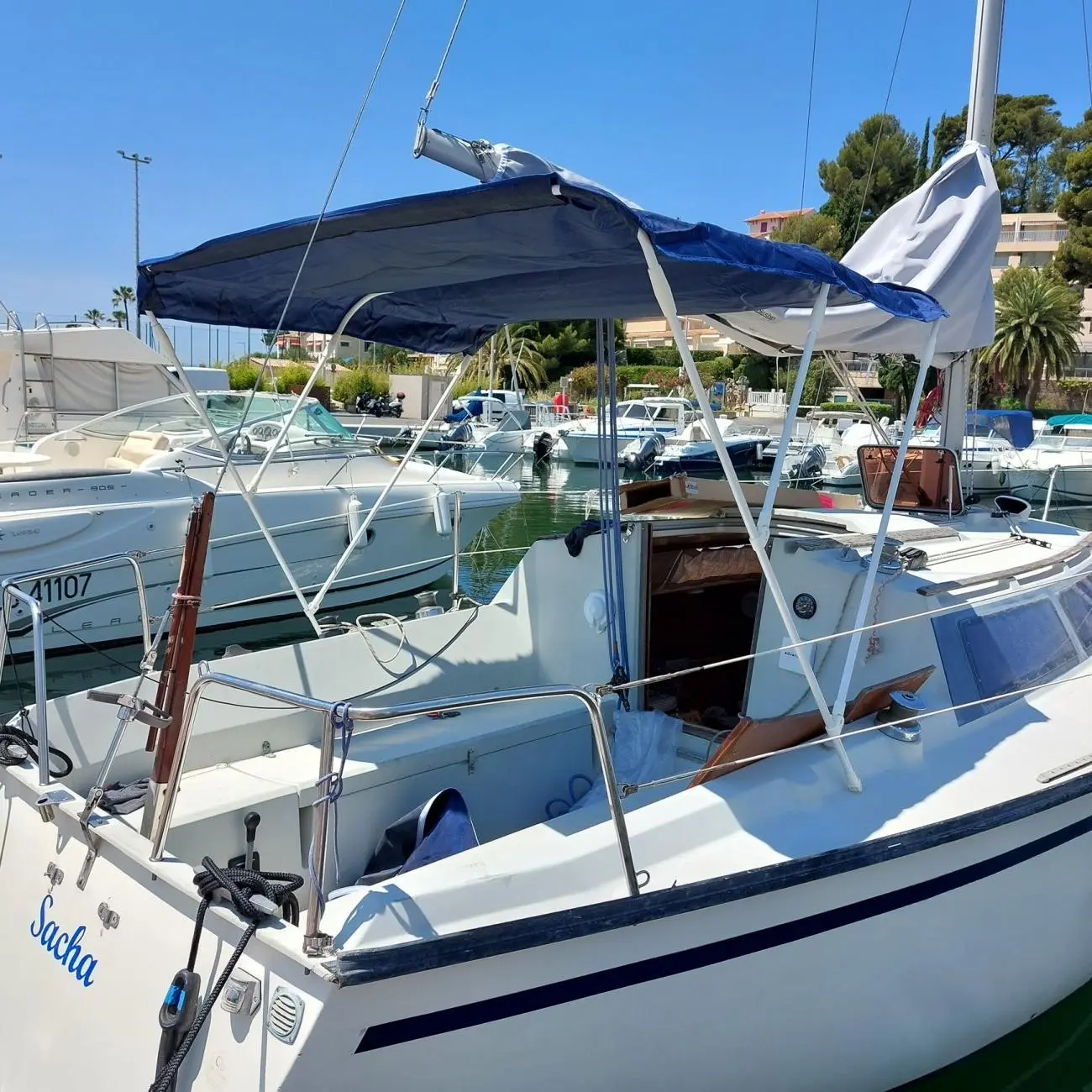 Dufour 2800 — Bateau à moteur amarré, vu de trois quarts dans un port, avec taud déployé.