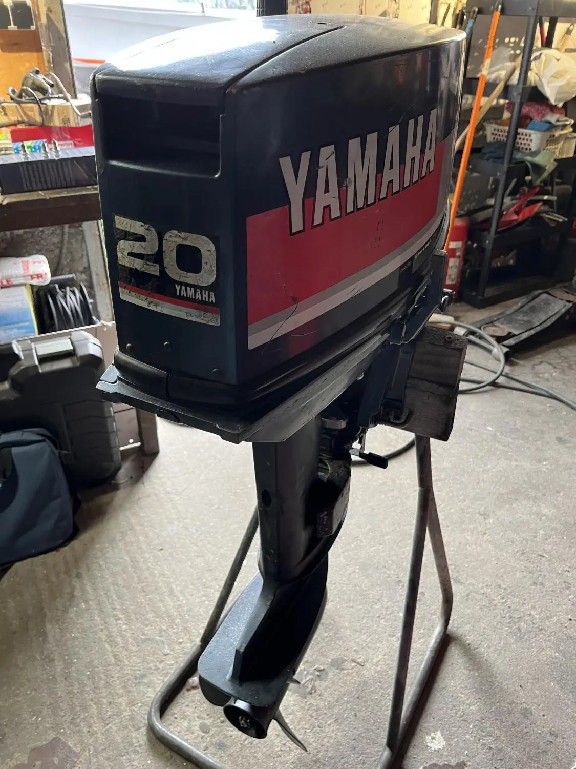 Quicksilver 420 Alu Rib — Moteur hors-bord Yamaha 20 présenté sur un support dans un atelier.