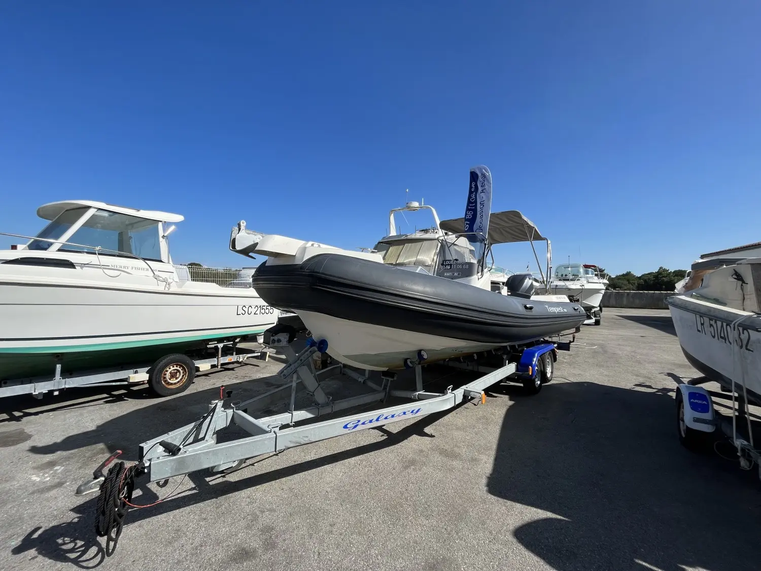 Capelli 700 — Bateau semi-rigide noir et blanc présenté sur sa remorque dans un parc à bateaux.