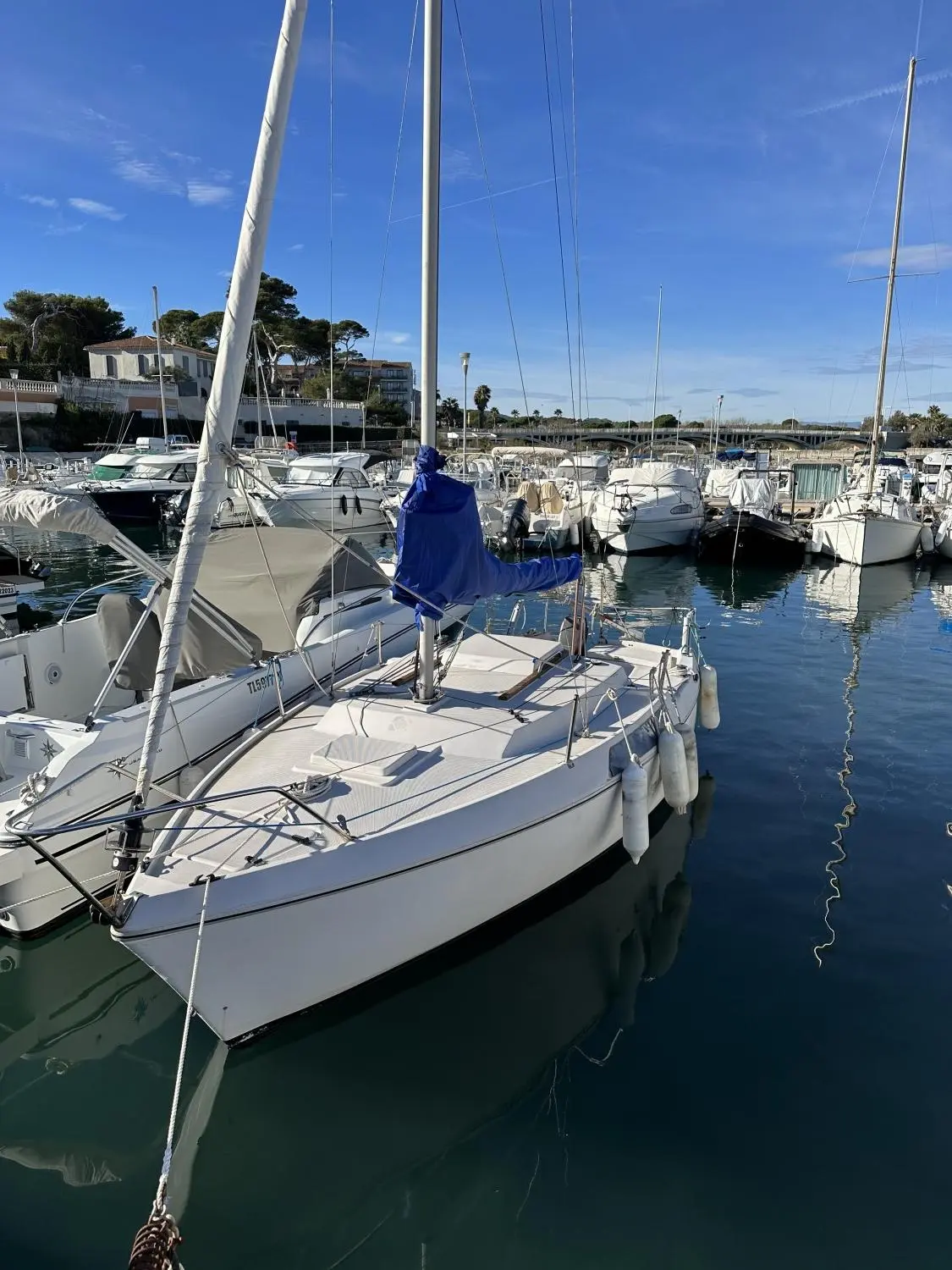 Jeanneau Flirt — Voilier amarré dans une marina, vu de trois quarts avant parmi d'autres bateaux.