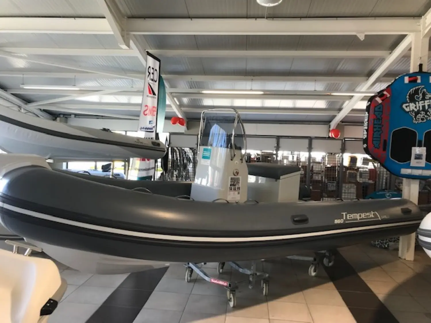 Capelli Tempest 560 — Semi-rigide gris exposé sur remorque dans un showroom nautique.